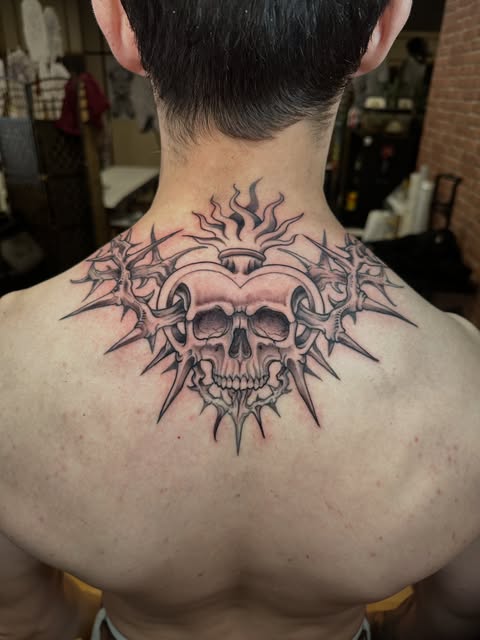 Tatuagem de caveira com composição ornamental nas costas, publicada pela Top Cat Studio